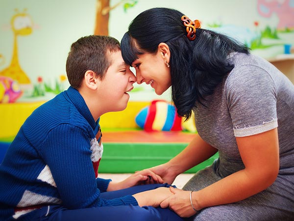 Disabled boy and his carer in rehabilitation centre