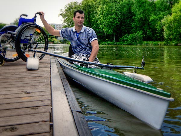 Disabled rower with his wheelchair on the dock